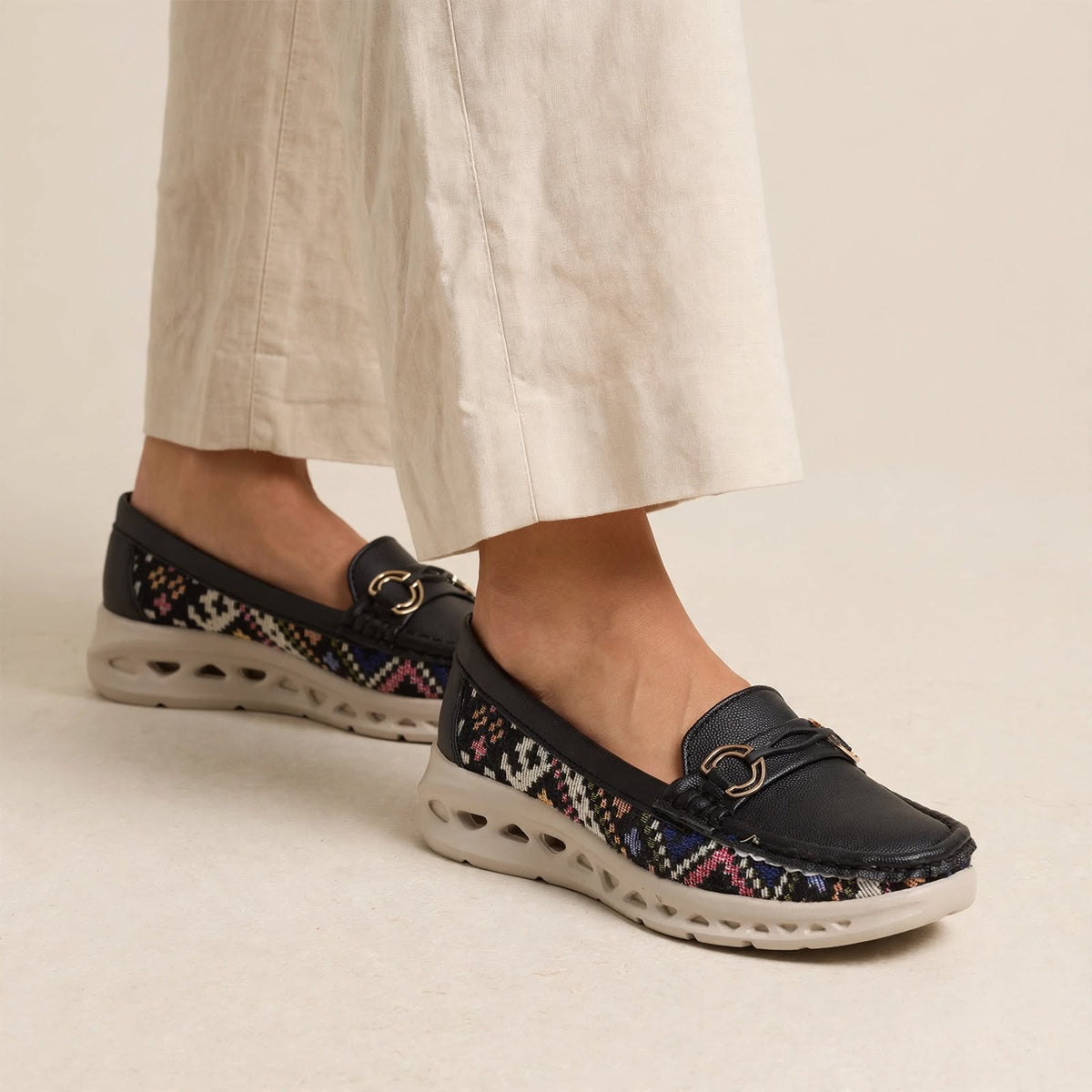 Women's black woven casual loafers with gold buckle - front view